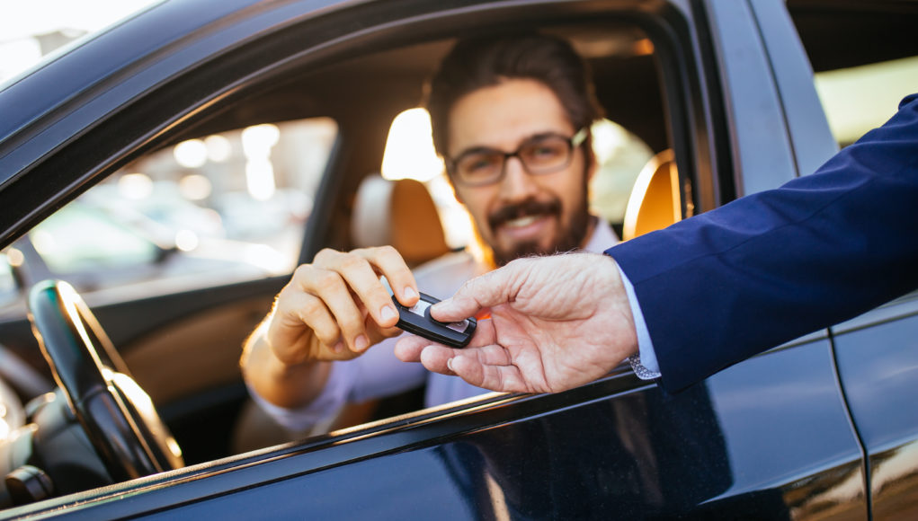 Young and handsome businessman buying used car.