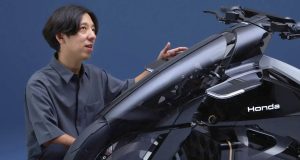 « Ne faire qu’un avec la moto », voilà comment le designer Honda définit ses innovations : un empattement long, des moteurs intégrés aux roues et l’absence de rétroviseurs. « Ne faire qu'un avec la moto », voilà comment le designer Honda définit ses innovations : un empattement long, des moteurs intégrés aux roues et l'absence de rétroviseurs.