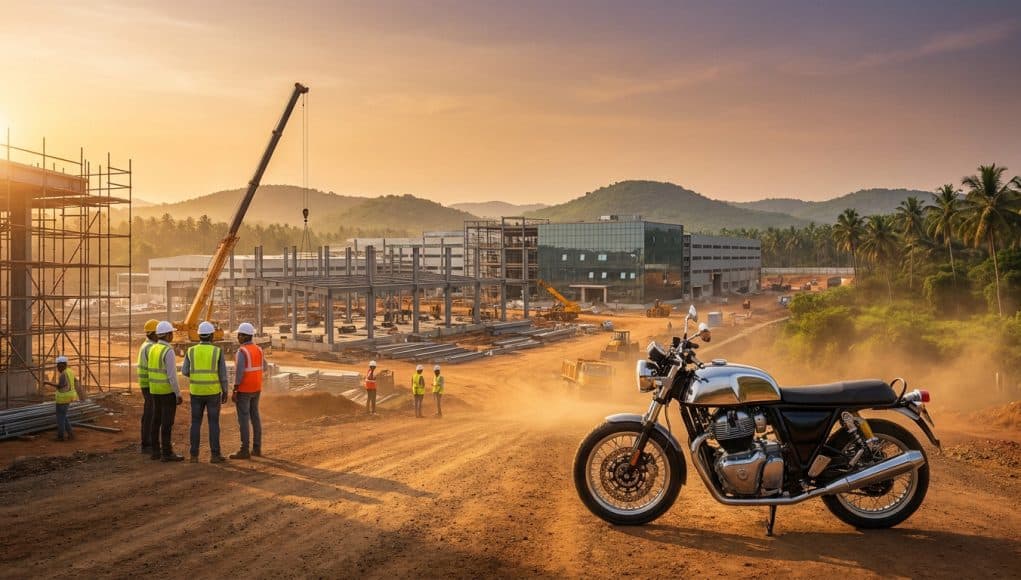 Usine Royal Enfield : le chantier de Tirupati Une moto Royal Enfield stationnée devant un chantier industriel en construction à Tirupati au coucher du soleil.