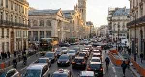 Circulation gare Nord : radiographie d’une saturation Vue en plongée de la circulation automobile, de bus et de cyclistes devant la Gare du Nord à Paris sous une lumière dorée.