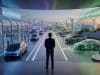 Akio Toyoda : sa vision multi-énergies face à l’électrique Un homme en costume observe une ville futuriste séparée entre des bornes électriques et des sources d'énergie diverses.