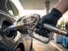 Fonctionnement du pistolet essence : les secrets de l’arrêt Une main gantée tenant un pistolet de pompe à essence avec un mécanisme interne visible inséré dans le réservoir d'une voiture.