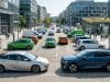 Le basculement du marché automobile européen électrique Voitures électriques et hybrides stationnées sur une place moderne entourée de bâtiments de bureaux dans une ville.