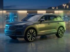 Nissan Qashqai électrique annulé : un virage stratégique Un SUV gris moderne exposé dans un studio technologique éclairé par des lumières bleues et vertes.