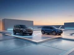 JLR : une stratégie hybride pour le Defender et l’Evoque Un Land Rover Defender et un Range Rover Evoque garés sur des plateformes lumineuses dans un décor architectural moderne.