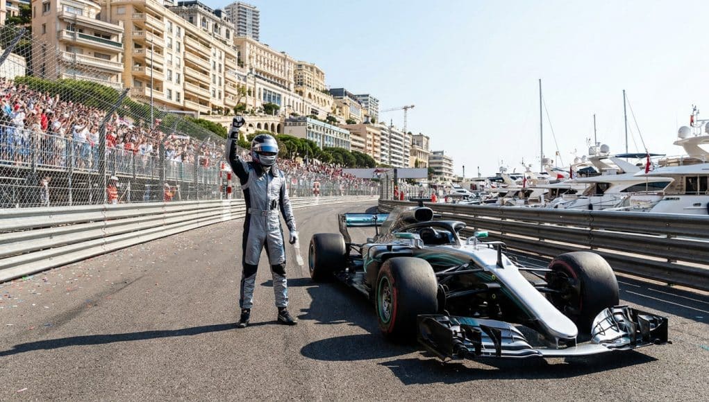 Kimi Antonelli célèbre sa pole position à Monaco Un pilote de course en combinaison célèbre sa pole position à côté de sa monoplace sur le circuit de Monaco.