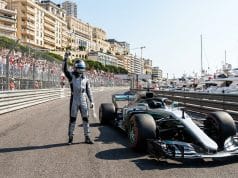 Pole de Kimi Antonelli à Monaco : l’analyse du prodige Un pilote de course en combinaison célèbre sa pole position à côté de sa monoplace sur le circuit de Monaco.