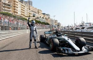 Pole de Kimi Antonelli à Monaco : l’analyse du prodige Un pilote de course en combinaison célèbre sa pole position à côté de sa monoplace sur le circuit de Monaco.