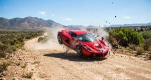 BeamNG.drive sur PS5 : la simulation de crashs arrive enfin Une Ferrari rouge en plein accident, projetée en l'air sur une route de terre avec des débris volant autour.
