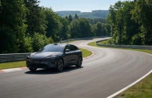 Xiaomi YU7 : record au Nürburgring entre IA et Citroën AX La voiture électrique Xiaomi YU7 GT grise circulant sur une courbe du circuit du Nürburgring entouré de forêt.