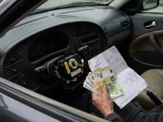 Rappel airbag Takata Saab : la facture s’alourdit en France Une main tenant des billets en euros et une facture à l'intérieur d'une voiture Saab avec un airbag démonté.