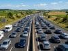 Prévisions Bison Futé juillet : anticipez les bouchons de l’été Vue aérienne d'un fort ralentissement sur une autoroute française bordée de champs en plein été.