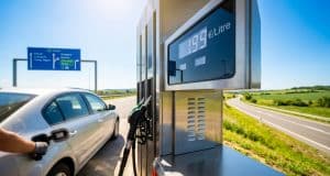 Tout sur le plafonnement du prix du carburant chez Total Une pompe à essence affichant 1,99 €/litre avec une voiture en arrière-plan sur le bord d'une autoroute.