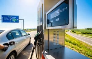 Tout sur le plafonnement du prix du carburant chez Total Une pompe à essence affichant 1,99 €/litre avec une voiture en arrière-plan sur le bord d'une autoroute.