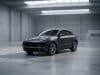 Fin de production du Macan thermique : quel avenir pour Porsche ? Un SUV Porsche Macan gris stationné au centre d'un vaste studio industriel au béton brut et à la lumière tamisée.