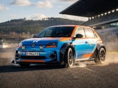 Kit carrosserie Milltek pour Renault 5 : l’hommage Groupe B Une Renault 5 électrique aux couleurs de course bleue et orange, équipée d'un kit carrosserie large sur un circuit.