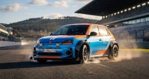 Kit carrosserie Milltek pour Renault 5 : l’hommage Groupe B Une Renault 5 électrique aux couleurs de course bleue et orange, équipée d'un kit carrosserie large sur un circuit.