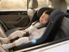 Dispositif anti-oubli enfant voiture : sécurité et loi Un jeune enfant dort paisiblement dans un siège auto équipé d'un capteur anti-oubli lumineux.