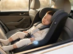 Dispositif anti-oubli enfant voiture : sécurité et loi Un jeune enfant dort paisiblement dans un siège auto équipé d'un capteur anti-oubli lumineux.