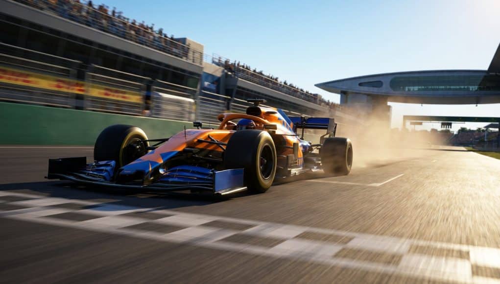 Victoire de Lando Norris en Hongrie 2026 Une monoplace McLaren orange et bleue franchit la ligne d'arrivée sur le circuit de Hongrie sous un soleil éclatant.