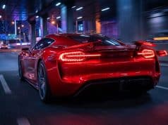 Brevet Ferrari feux arrière : le futur de l’aérodynamique Une voiture de sport rouge Ferrari circulant de nuit sur une autoroute urbaine, mettant en avant ses feux arrière innovants.