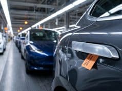 Rappel voitures poignées porte : la Chine face au danger Gros plan sur une poignée de porte de voiture avec une étiquette orange indiquant un défaut de mécanisme en usine.