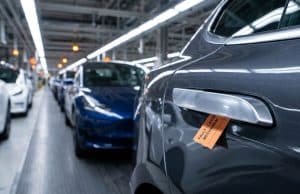 Rappel voitures poignées porte : la Chine face au danger Gros plan sur une poignée de porte de voiture avec une étiquette orange indiquant un défaut de mécanisme en usine.