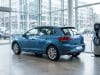 Ventes renault clio 6 : analyse d’un début complexe en 2026 Une voiture bleue stationnée à côté d'une borne de recharge électrique dans une concession automobile vitrée.
