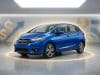 Pourquoi la Honda Fit d’occasion est-elle devenue si chère Une Honda Fit bleue garée dans un studio avec des symboles de dollar et des graphiques en arrière-plan.