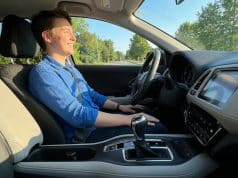 Le permis boîte automatique : une formation simplifiée Un jeune homme souriant au volant d'une voiture à boîte automatique lors d'une journée ensoleillée.