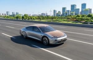 Voiture solaire Luminetta : vers une autonomie énergétique La voiture solaire argentée Luminetta roule sur une route moderne avec des panneaux solaires visibles sur le toit et capot.