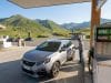 Économies et prix carburant en Andorre : l’analyse complète Un homme fait le plein de sa voiture dans une station-service en Andorre avec les montagnes en arrière-plan.