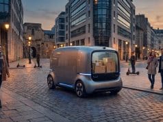 Véhicule de livraison autonome en France : le cadre légal Véhicule de livraison autonome futuriste transportant des colis dans une rue piétonne pavée en France.
