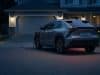 Rappel park outside : le danger d’incendie des véhicules en 2026 Une voiture électrique grise stationnée en extérieur et branchée sur une prise domestique devant une maison la nuit.
