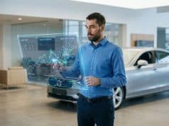 IA et prix voiture occasion : vers une cotation plus juste Un homme examine des données de marché sur une interface holographique devant une voiture dans une concession.