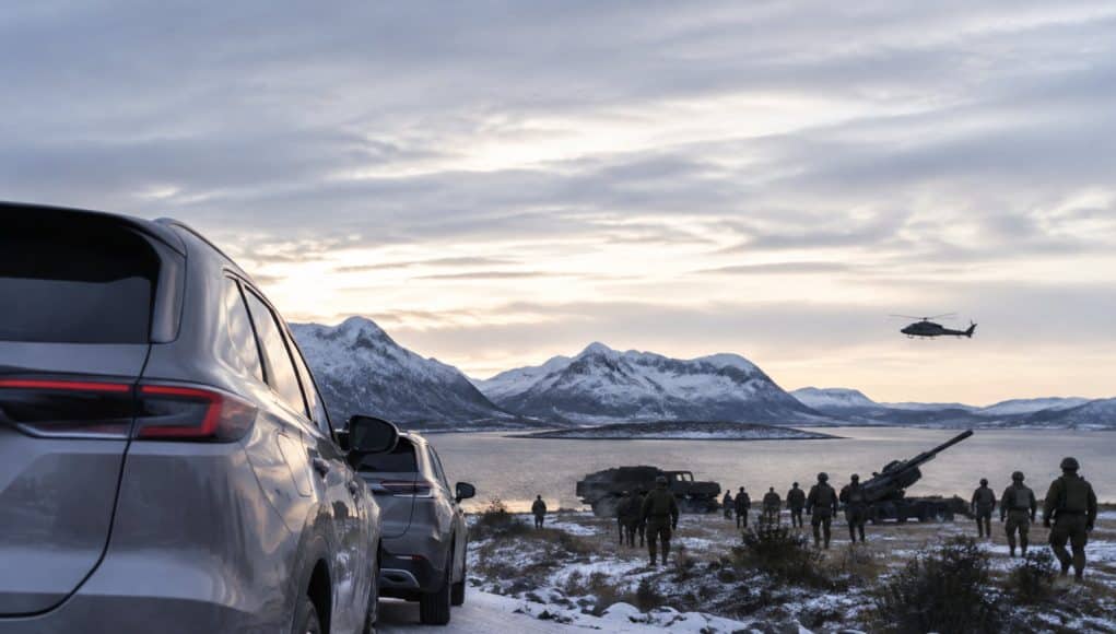 Espionnage présumé lors d'un exercice militaire en Norvège Deux voitures observent des soldats et un hélicoptère militaire près d'un fjord enneigé en Norvège.