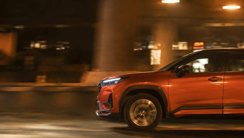 Honda Elevate : un SUV dynamique en conduite nocturne Un SUV orange Honda Elevate circulant de nuit avec un effet de flou de mouvement sur la route.