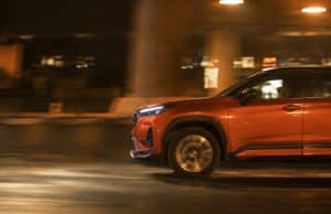 Analyse du Honda Elevate : SUV compact produit en Inde et freins à sa commercialisation en Europe Un SUV orange Honda Elevate circulant de nuit avec un effet de flou de mouvement sur la route.