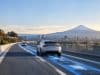 Honda et Taisei prévoient un test de recharge par induction au Japon Voitures électriques roulant sur une autoroute japonaise avec une animation lumineuse bleue illustrant la recharge sans fil.