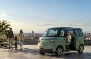 Fiat Multiplina : le quadricycle familial électrique de 2028 Une Fiat Multiplina verte garée sur une terrasse avec une famille en arrière-plan et une vue sur Rome.