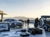 Accélération des cycles de conception automobile et complexification électronique : quels risques ? Ingénieurs travaillant sur des voitures prototypes et des composants électroniques en extérieur au coucher du soleil.