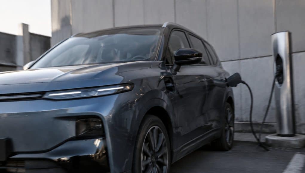 SUV Leapmotor B10 bleu gris en charge sur une borne publique dans un espace urbain.
