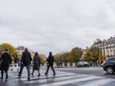 Conformité des passages piétons à Paris : loi LOM et sécurité routière Piétons traversant une rue à Paris sur un passage clouté sous un ciel gris.
