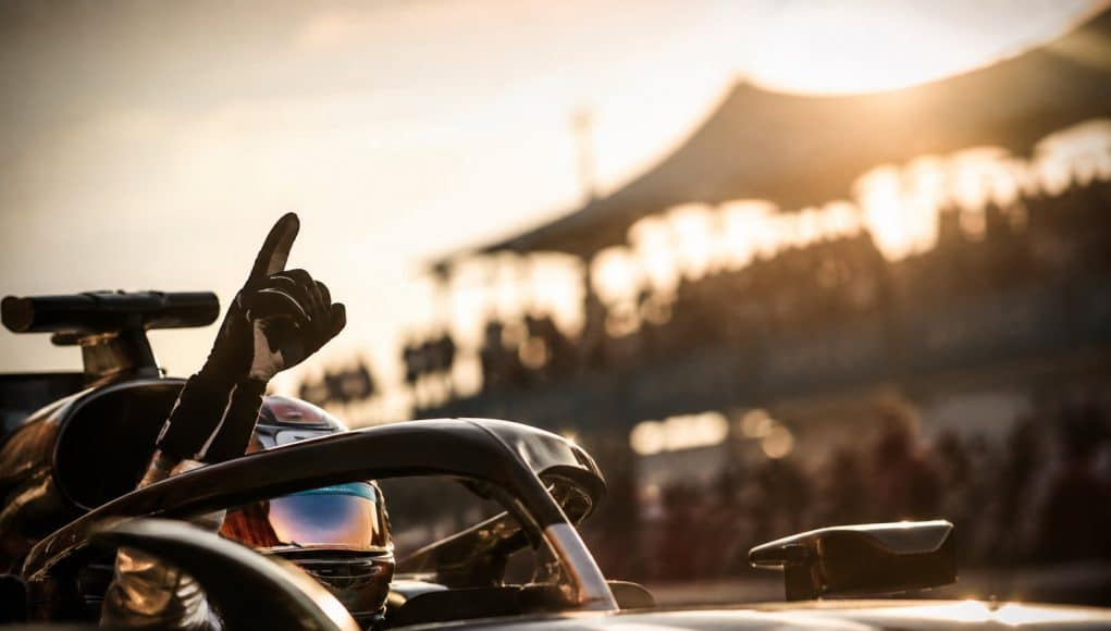 Un pilote de Formule 1 portant un casque lève le doigt en signe de victoire après sa pole position au GP des États-Unis.